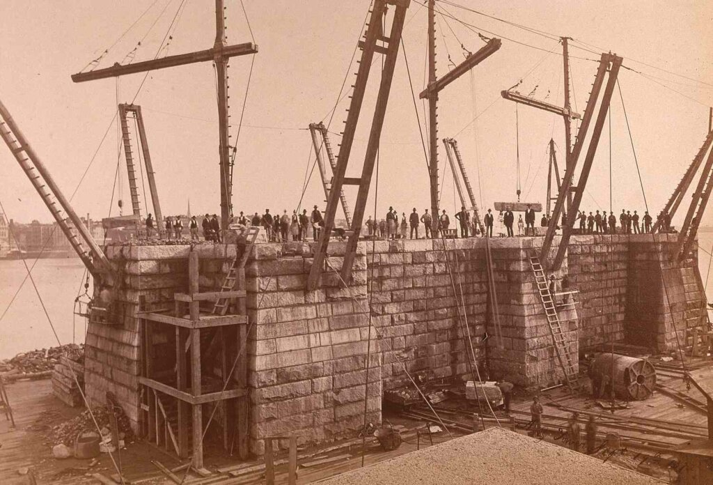 Archive photo showcasing the foundation construction of the Brooklyn Bridge, featuring the development of the massive stone towers and intricate caisson work, marking a significant phase in this groundbreaking engineering project