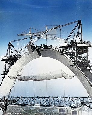 the Gateway Arch during its construction phase, showing the partially completed arch structure, scaffolding, and workers, illustrating the impressive engineering and construction efforts that brought this iconic monument to life in St. Louis, Missouri